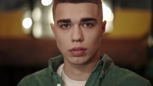 Crop View of Young Man with Stylish Haircut Raising Head and Looking to Camera alt