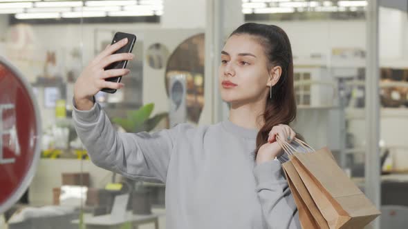Lovely Young Woman Taking Selfies with Her Smart Phone at the Shopping Mall