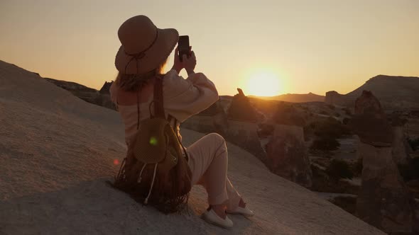 Woman Photographing the Valley of the Monks at Sunset alt