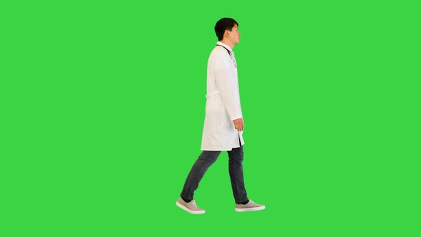 Young Asian Doctor Walks Seemingly Tired on a Green Screen Chroma Key alt