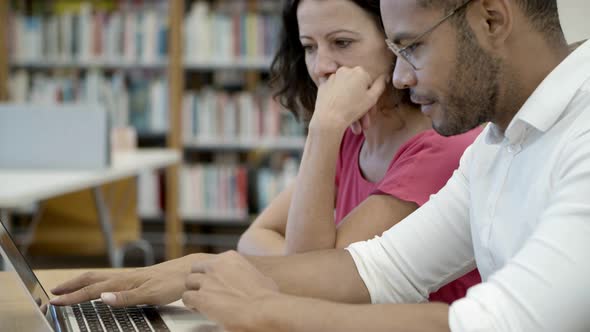 Concentrated Young People Reading Information From Laptop alt