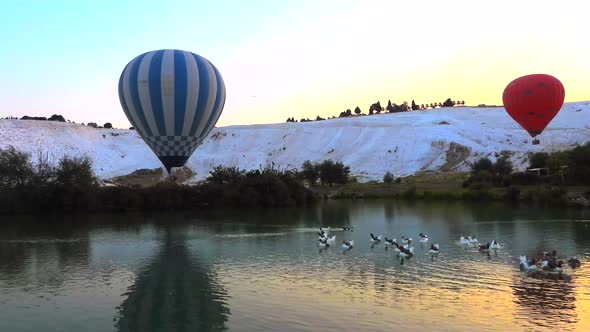 Hot Air Balloons in White Travertines and Lake of Pamukkale, a Touristic Natural World Heritage Site