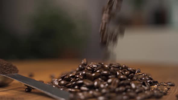 Roasted coffee beans falling onto a wooden surface. alt