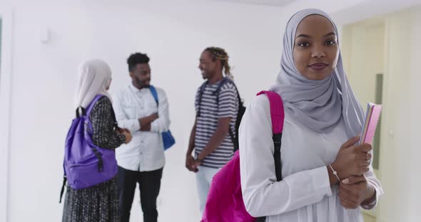 African Female Student with Group of Friends in Background Wearing Traditional Islamic Hijab Clothes alt