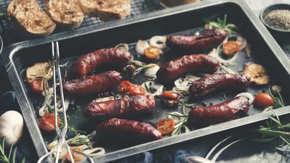 Tasty Grilled Homemade Rosemary Sausages Placed on Iron Frying Tray Over Rustic Dark Stone Table alt