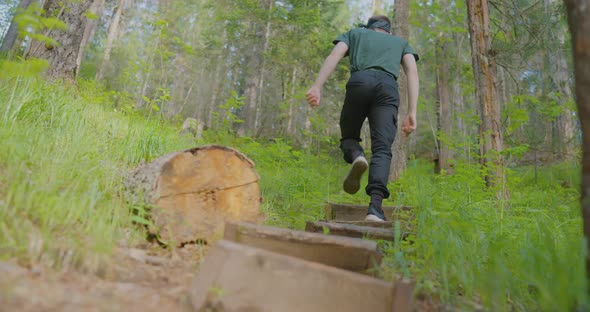 The traveler is climbing on the steps in the wild forest The wild Krasnoyarsk Stolby alt