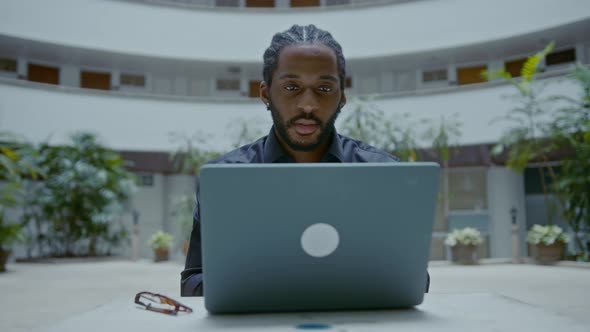 Young AfricanAmerican Businessman Working with a Laptop on the Street alt
