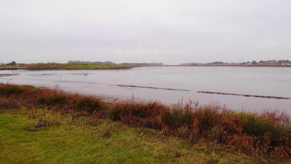 Aerial Low Flying Over Flood Plain Beside Noord In Ridderkerk With Birds Flying Past alt