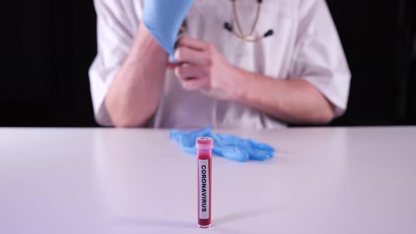Doctor wearing blue gloves and showing test-tube with positive coronavirus test result