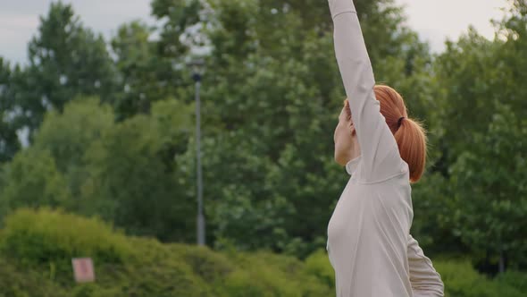 Side view of woman doing stretching outdoor. alt