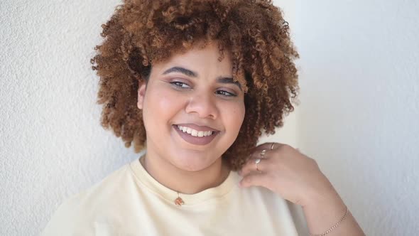 Beautiful Happy Smiling Curvy Plus Size African Black Woman Afro Hair with Make Up Posing in Beige