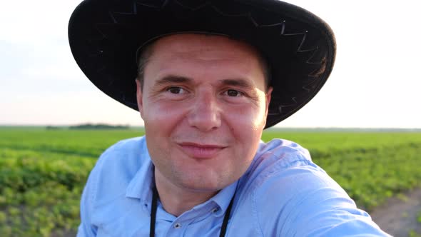 A Farmer Contacts the Office By Video Call From His Field at Sunset alt