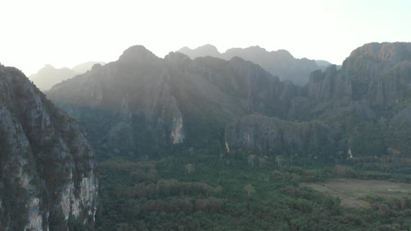 Aerial: Vang Vieng backpacker travel destination in Laos, Asia. Sunset scenic alt