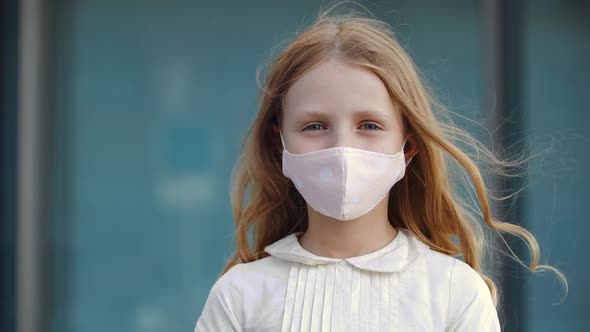 Headshot of Positive Girl Stands Outdoors, Shows Sign of Approval Puts Finger Up, Wears Medical alt