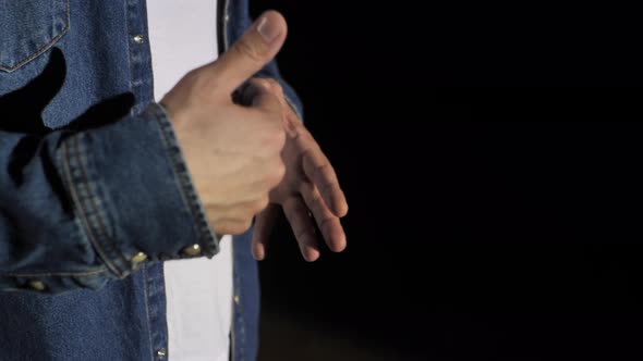 Closeup of the Hands of a Young Male Business Coach Speaking Passionately From the Stage in a Dark alt