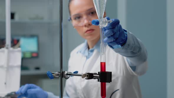 Close Up of Scientist Using Laboratory Glassware on Desk alt