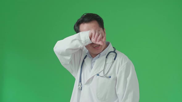Tried Doctor With Stethoscope And White Coat Taking Off Glasses While Standing In Front Green Screen alt