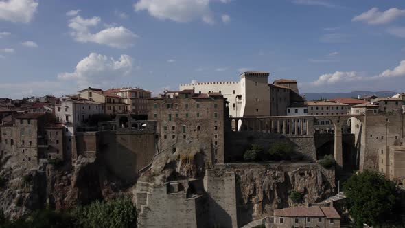 -SHOT: slider, side-DESCRIPTION: drone video over the side of Pitigliano, Italy-HOUR.WEATHER: summ alt