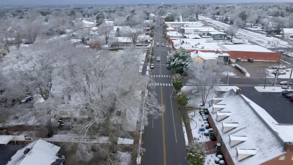 Drone shot of small town main street USA after snowfall alt