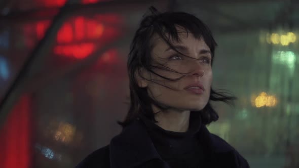 Melancholic Emotive Caucasian Female Standing Staring Away In The City At Night While It Rains alt