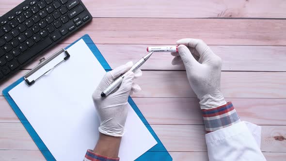 Laboratory Technician Hand Holding Blood Test Tube  alt