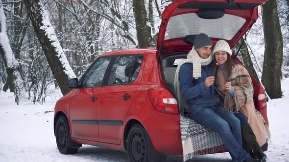 Tea party in car trunk - loving couple sits in car trunk in Valentine's day
