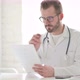 Doctor Reading Documents While Sitting in Office - VideoHive Item for Sale