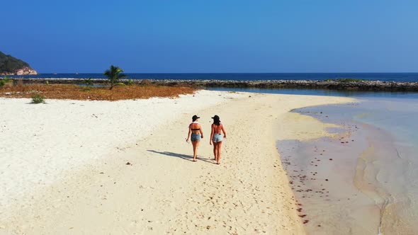 Ladies enjoying life on marine tourist beach trip by transparent water and white sandy background of