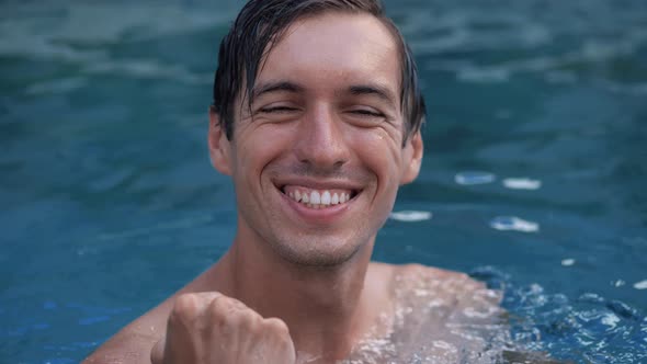 Amazed Young Man Shocked Showing Yes Winner Gesture on Vacation In Swimming Pool