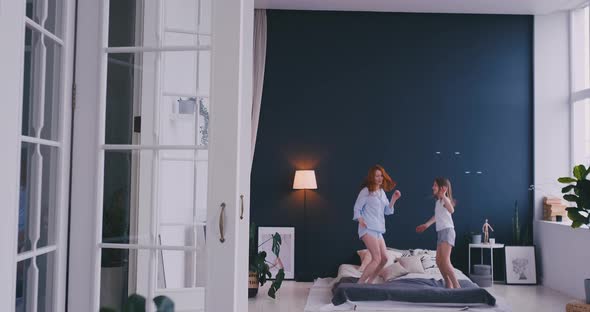 Mother and Daughter Jumping on the Bed, Happiness, Joyful alt