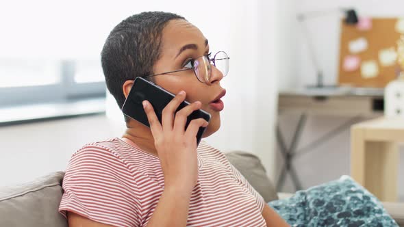 African Woman Calling on Smartphone at Home alt