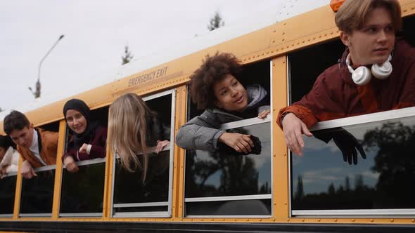 Students with Heads Out of School Bus Windows alt
