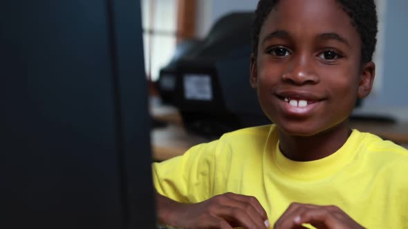 Little Boy Smiling at Camera During Computer Class alt