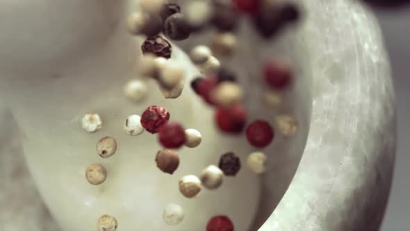 Granite Mortar and Colored Pepper Grain Spice Species Falling in Slow Motion alt