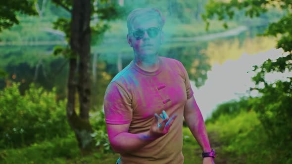 A Young Handsome Man in Sunglasses Pours Blue Powder Over Himself