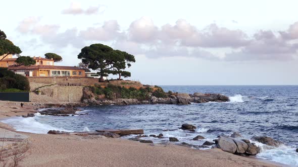 Picturesque island and person walking sandy beach under cloudy sky alt