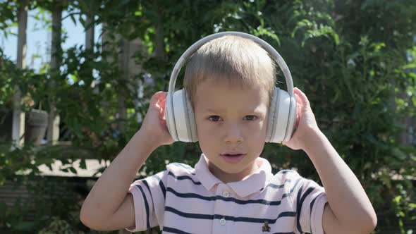 Portrait of Cute Little Boy With Headphones Listening to Music alt
