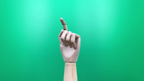 Wooden hand on green background
