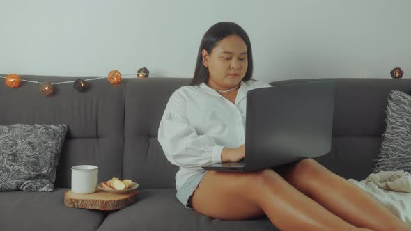 Asian Plus Size Woman Working Online with Laptop at Home alt