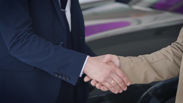 An Unrecognizable Manager Shakes Hands with a Client and Hands Over the Car Key alt