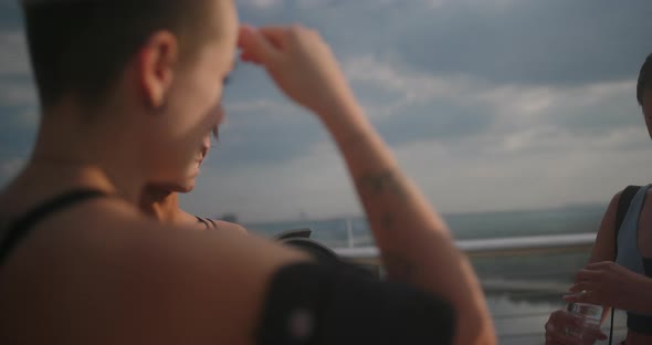 Athletes Stand By Bridge Banisters Talking Latin Girl Smiles alt