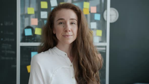 Portrait of Attractive Young Woman Employee Smiling Indoors in Creative Office alt