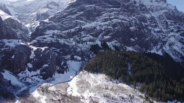 aerial footage flying over snowy glacial landscape over a river in direction of big limestone cliffs alt