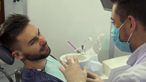 Dentist Explains Something To His Client