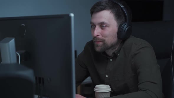 Guy in Headphones Having Video Conferevce at Home Office alt