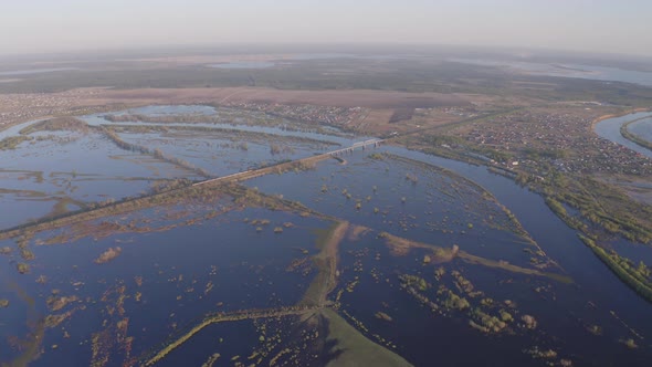 Aerial Drone Footage of a Freight Train Passes a Bridge in High Water