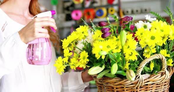 Female florist watering flowers alt