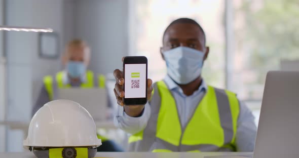 African Engineer Wearing Safety Mask in Office Showing Smartphone with Vaccinated Qrcode at Camera alt