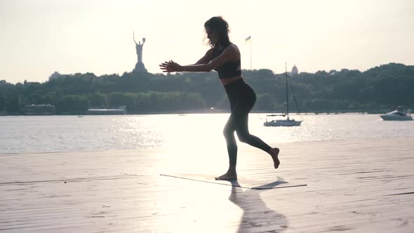 the Girl Is Engaged in Fitness on the City River