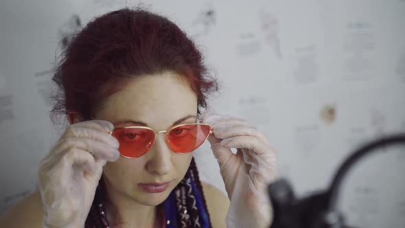 Woman Wearing Gloves Puts on Sunglasses Looks at Camera and Removes Accessory alt